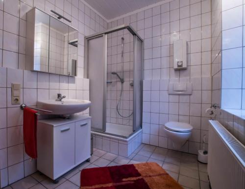 a bathroom with a sink and a shower and a toilet at Ferienwohnung Scheid in Lahr