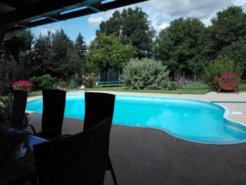 a swimming pool with chairs in front of it at Ubytování Carmen in Česká Skalice