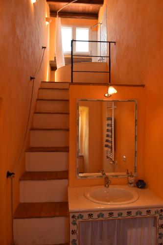 a bathroom with a sink and stairs with a mirror at Tenuta Donna Caterina in Tessennano
