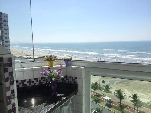 a bathroom with a sink and a view of the beach at Cheryl in Praia Grande