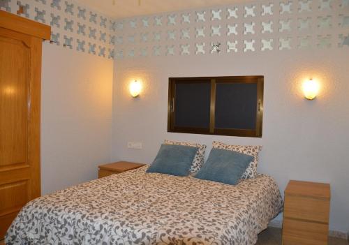 a bedroom with a bed with two blue pillows at Ruzafa Rincon Español in Benidorm