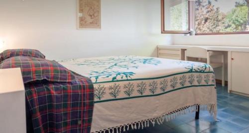 een slaapkamer met een bed, een tafel en een bureau bij Villa Betty in Porto Clementino