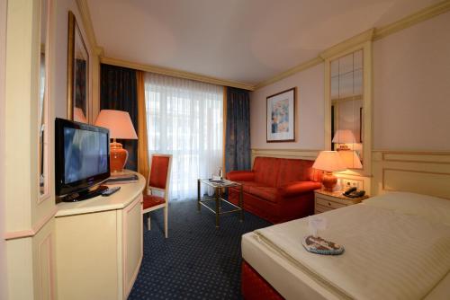 a hotel room with a television and a bed at The Monarch Hotel in Bad Gögging