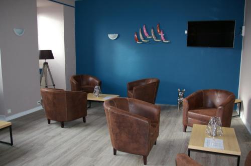 a waiting room with chairs and tables and a tv at Queen Serenity Hotel in Redon