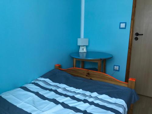 a blue bedroom with a bed and a blue wall at BaletyuKatany in Białka Tatrzanska