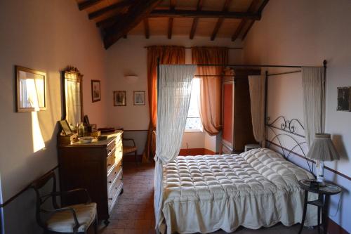 a bedroom with a bed and a dresser and a window at Attico Panoramico in dimora storica in Canino