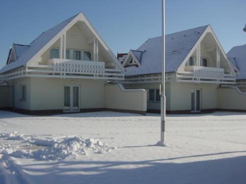 a large white house with a roof in the snow at Gólya Villa Park in Velence