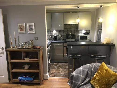 a kitchen with a counter and two bar stools at OurHaus in Beverley