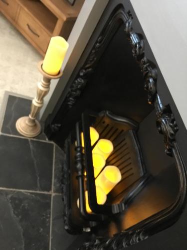 a fireplace with two candles on top of it at OurHaus in Beverley
