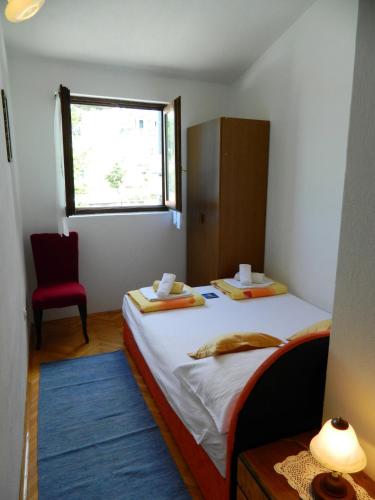 a small bedroom with a bed and a window at Ema in Brela