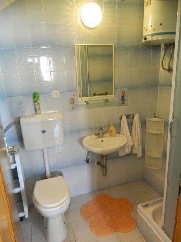 a bathroom with a toilet and a sink at Ema in Brela