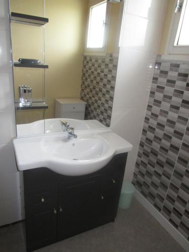 W łazience znajduje się umywalka i lustro. w obiekcie Maison proche Mont St Michel et St Malo w mieście Roz-sur-Couesnon
