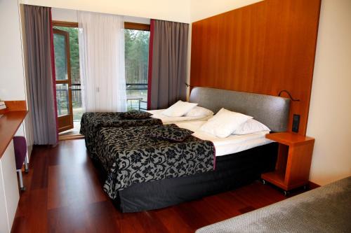 a hotel room with two beds and a window at Break Sokos Hotel Vuokatti in Vuokatti