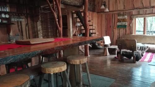 a bar with stools in a room with wooden walls at Cabañas Rústicas Pucón Río Trancura in Pucón