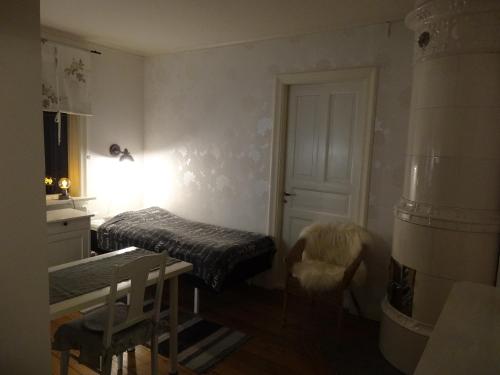 a small room with a bed and a table and a window at Gröna Lena in Sunne