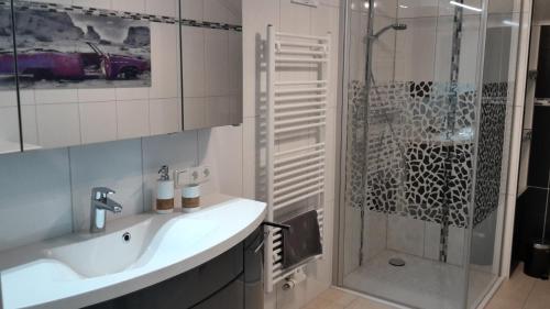 a bathroom with a sink and a shower with a shower at Greenheart Aussee in Obersdorf