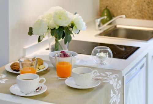 una encimera de cocina con 2 tazas y 2 vasos de zumo de naranja en Numa Rúa Travesa, en Santiago de Compostela