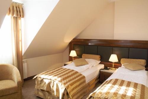 Pokój hotelowy z 2 łóżkami i krzesłem w obiekcie Hotel Sulisław w mieście Sulisław