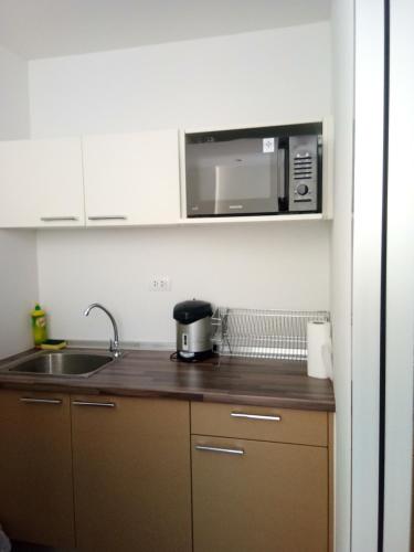 a kitchen with a sink and a microwave at Mosaic Condominium A34M by malai in Ban Bua Phut