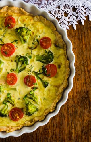un pastel con brócoli y tomates en un plato en una mesa en Orańska, en Międzygórze