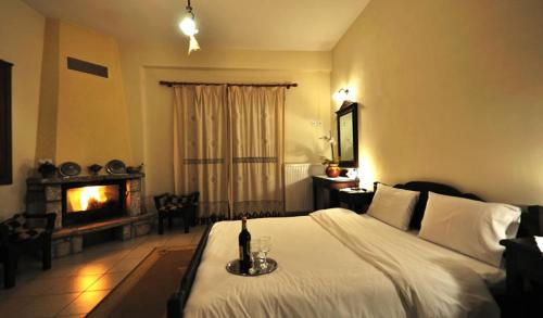 a bedroom with a large bed with a fireplace at To Balkoni tis Limnis Plastira in Neochori