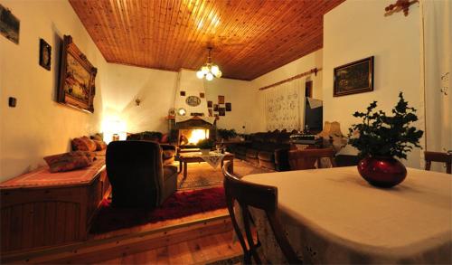 ein Wohnzimmer mit einem Tisch und einem Sofa in der Unterkunft To Balkoni tis Limnis Plastira in Neochóri