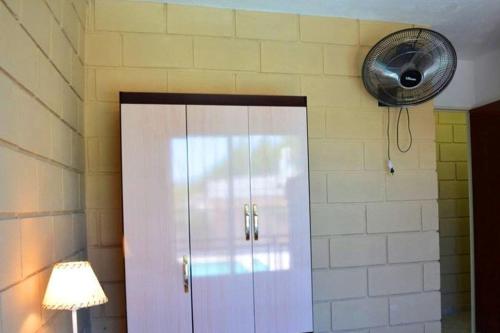 Armario blanco en una habitación con ventilador en Malaquias en Villa Carlos Paz