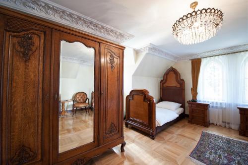 a bedroom with a large wooden cabinet and a bed at Pałac Sulisław in Sulisław