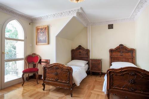 a bedroom with two beds and a red chair at Pałac Sulisław in Sulisław