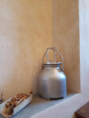a tea kettle sitting on a shelf next to a plate of food at casa del cirillo in Ornica