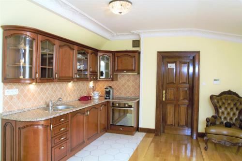 a kitchen with wooden cabinets and a sink at Pałac Sulisław in Sulisław