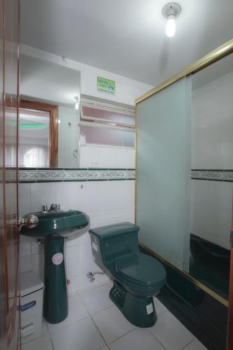 a bathroom with a green toilet and a sink at Hotel Plaza del Teatro in Quito