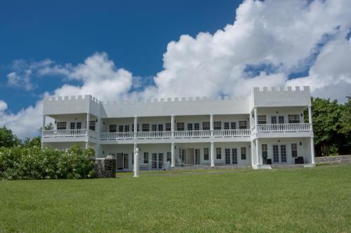a large white house with a large yard at Castles Apartments in Castries