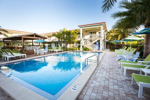 a swimming pool with lounge chairs and a resort at Sun Dek Beach House in Boynton Beach