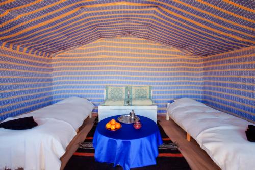 マハミドにあるBivouac La Dune Blancheのベッド2台、カボチャの置いたテーブルが備わる客室です。