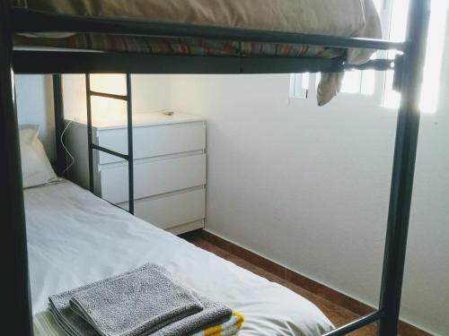 a bedroom with a bunk bed with a towel at Casa Buenavista in Almuñécar