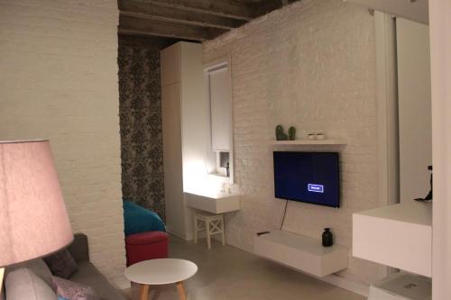 a living room with a tv on a white brick wall at Momo Apartment in Belgrade