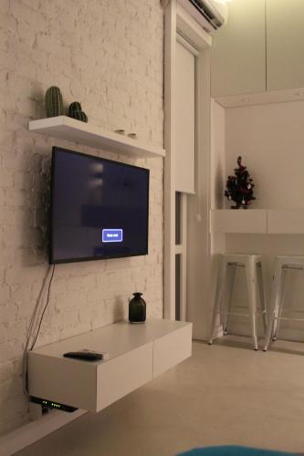 a living room with a tv on a white brick wall at Momo Apartment in Belgrade