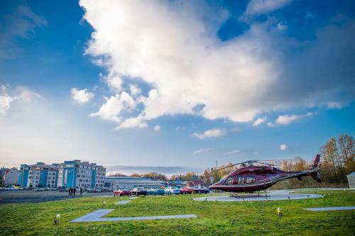 a helicopter is parked in a grass field at King's Resort - casino and hotels in Rozvadov