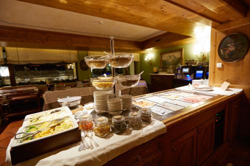 a buffet with wine glasses and food on a table at Gran Baita Hotel & Wellness in Courmayeur
