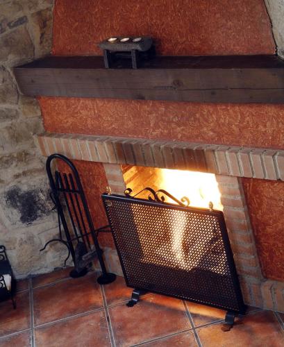 a fireplace with a bench in front of it at La Xamoca Apartamentos Rurales in Campiellos