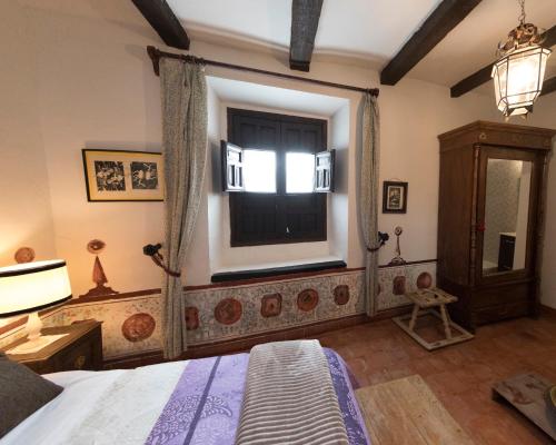 a bedroom with a bed and a window at Palacete Sol de Mayo in Úbeda