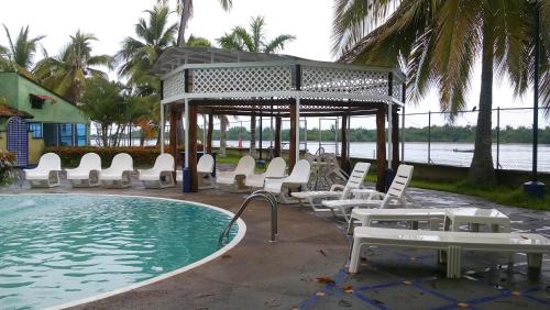 a swimming pool with chairs and a gazebo at Hotel Marina San Blas in San Blas