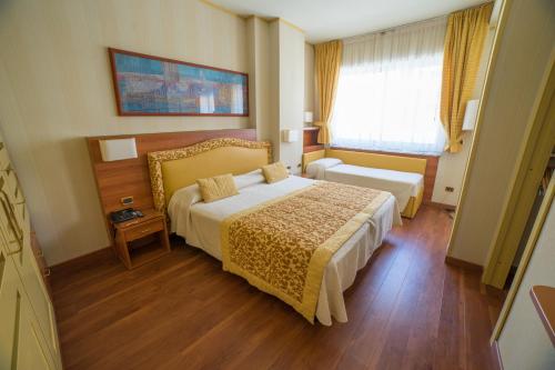 pokój hotelowy z łóżkiem i oknem w obiekcie Hotel Garden Lido w mieście Loano