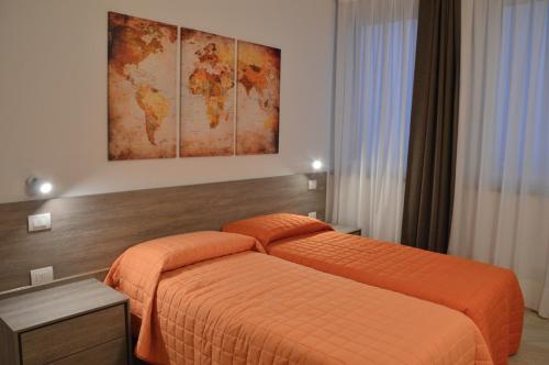 una habitación de hotel con 2 camas y un mapa en la pared en Il Sorriso, en Negrar