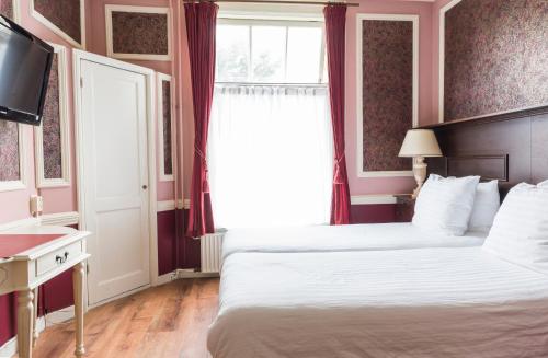a hotel room with a bed and a window at Hotel Fidder - Patrick's Whisky Bar in Zwolle