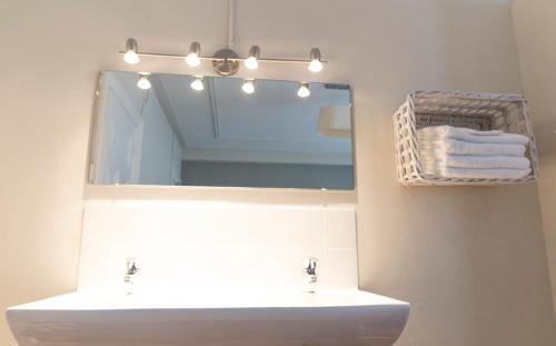 a bathroom with a sink and a mirror and towels at Hotel Fidder - Patrick's Whisky Bar in Zwolle