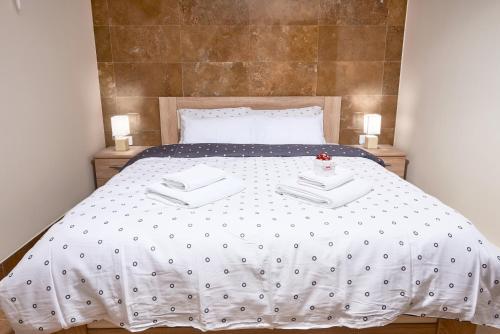 a bed with a white bedspread and pillows at Apartments Residence Portofino in Kotor