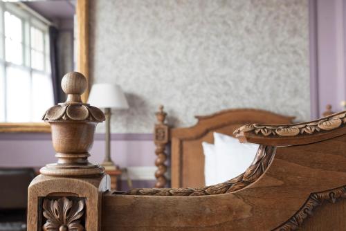 a bedroom with a wooden bed and a mirror at Hotel Fidder - Patrick's Whisky Bar in Zwolle