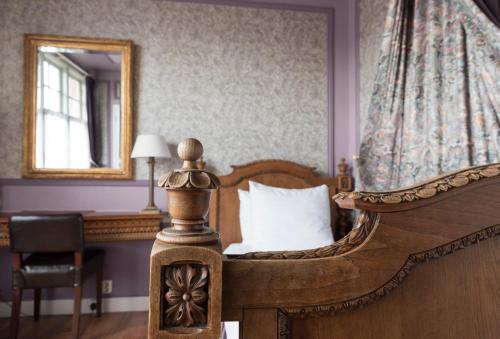 a bedroom with a wooden bed and a mirror at Hotel Fidder - Patrick's Whisky Bar in Zwolle